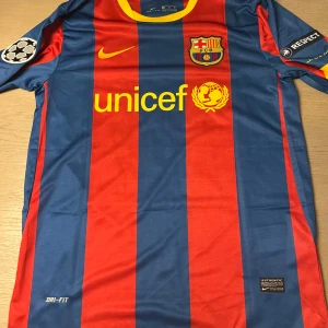 FC Barcelona fotbollströja - Säljer en klassisk FC Barcelona fotbollströja från Nike med Messi 10 på ryggen. Tröjan har de ikoniska blå och röda ränderna med gula detaljer och klubbmärket på bröstet. Kortärmad design med Dri-FIT material för optimal komfort. Perfekt för alla Barca-fans! 🌟