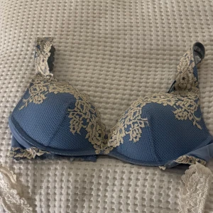 Blå bh med spetsdetaljer -  blå bh från intimissimi med  spetsdetaljer i beige. Den har justerbara axelband och en, bekväm passform. Inte använd ofta använd Minst 4 gånger.   STORLEK 75C 