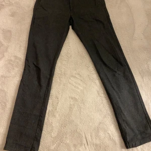 Svarta byxor från East West - Snygga svarta byxor från East West med en klassisk design. Byxorna har en rak passform och är utrustade med knappar både fram och bak. Perfekta för en stilren look.