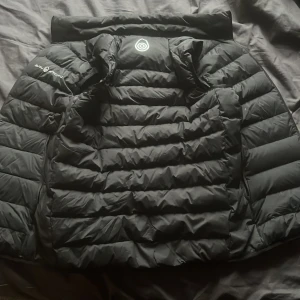 Svart dunväst från Sail Racing - Snygg svart dunväst från Sail Racing med dragkedja framtill. Ny pris cirka 1700, perfekt höst/sommar väst 