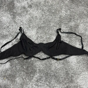 Svart spets bh  - Elegant svart bh med spetsdetaljer och justerbara axelband. Perfekt för en stilfull look med en touch av elegans.