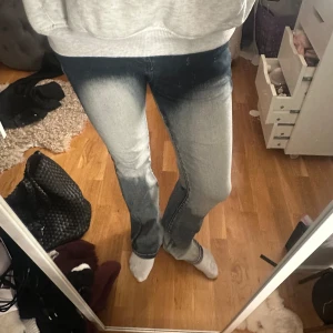 Grå jeans med tvättad effekt - Snygga grå jeans med en cool tvättad effekt. De har en straight passform och är perfekta för en avslappnad stil. Kombinera med en hoodie för en bekväm look.