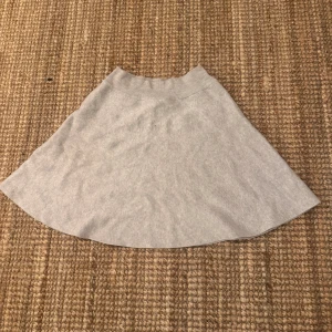 Grå kjol från Gina Tricot - Snygg grå kjol från Gina Tricot i en enkel och stilren design. Kjolen har en mjuk och bekväm passform, perfekt för en avslappnad look. Den är tillverkad i ett stretchigt material som ger en skön känsla hela dagen.