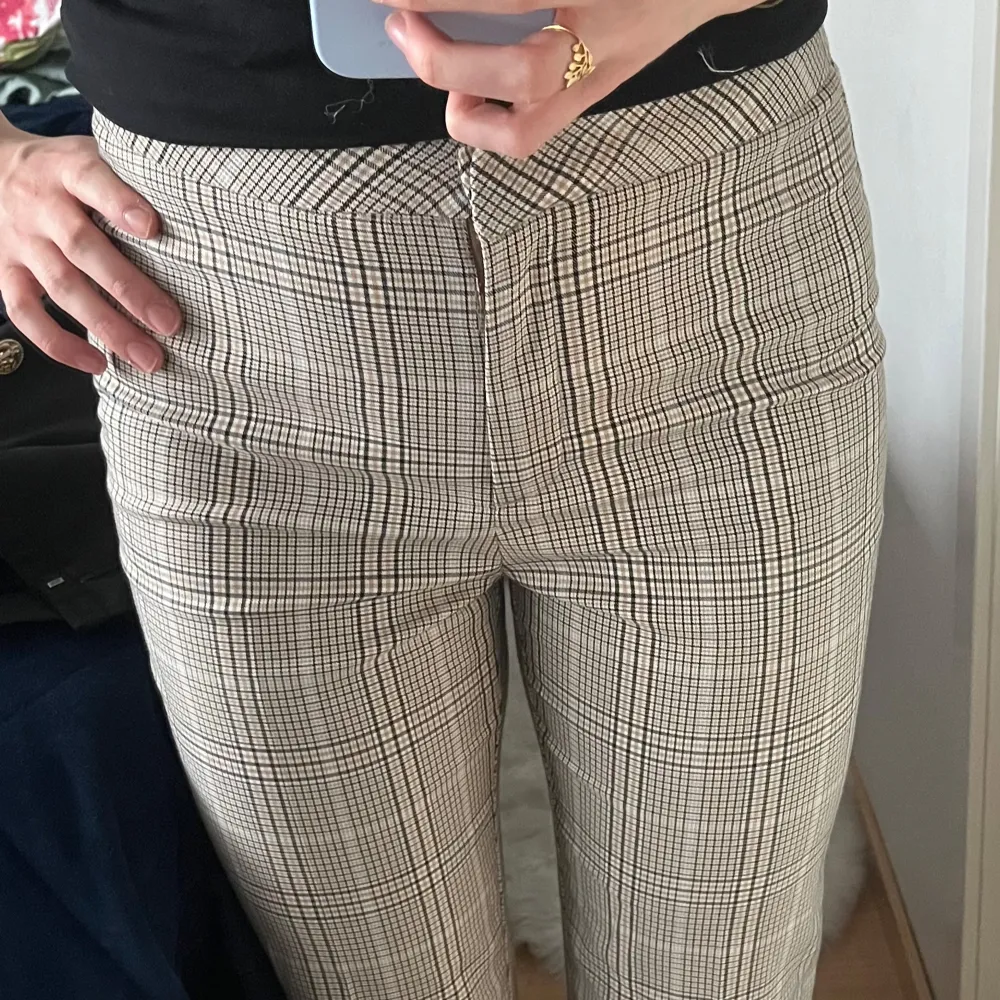 Snygga rutiga byxor i beige och svart med hög midja och rak passform. Perfekta för en stilren look. Står att de är strl L, men jag har M och de passar mig bra. Skulle säga M/L då materialet är lite stretchigt.. Farkut & Housut.