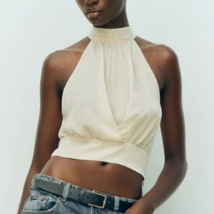 Zara Satin halterneck topp  - Säljer denna snygga vita halterneck topp i satin material  som är perfekt för varma sommardagar eller en kväll ute. Den är helt ny från zara’s butik med tag på och alldrig använd den finns även Inte längre kvar på deras hemsida eller i deras butiker. 