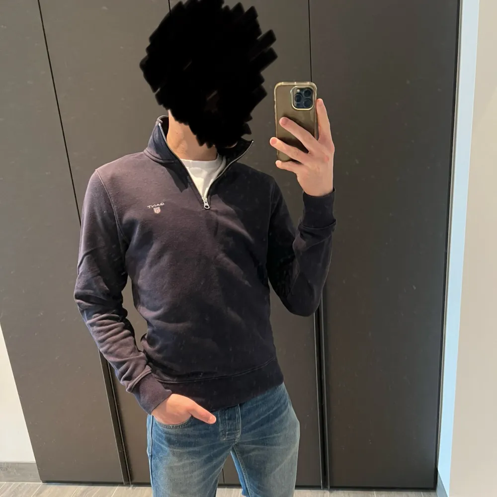 Säljer en stilren mörkblå tröja från Gant med halv dragkedja och broderad logga på bröstet. Tröjan har långa ärmar och ribbade muddar vid ärmslut och nederkant. Perfekt för en avslappnad look.. Neuletakit & Villapaidat.