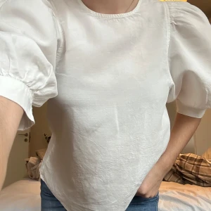 Vit blus från Samsøe Samsøe - Säljer en stilren vit blus från Samsøe Samsøe med puffiga trekvartsärmar och knappar längs ryggen. Perfekt för en elegant look.✨