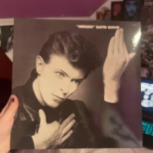 "Heroes" av David Bowie + fan club membership - Säljer vinylen"Heroes" av David Bowie + extras.Omslaget har ett ikoniskt svartvitt foto av artisten. Baksidan listar låtarna som finns på vinylen och innutin fins ett paper med låttexterna på. Vinylen bara använd ungefär 3-5 gånger så den är i bra skick! Brevid vinylen finns ett ’David Bowie fan club’ de är 1 år membership och då får du olika sorters posters, ’concert photos with signature’, fan club brev varje fjarde månad, eget David bowie fan club membership card och annat. Kontakta för mera.