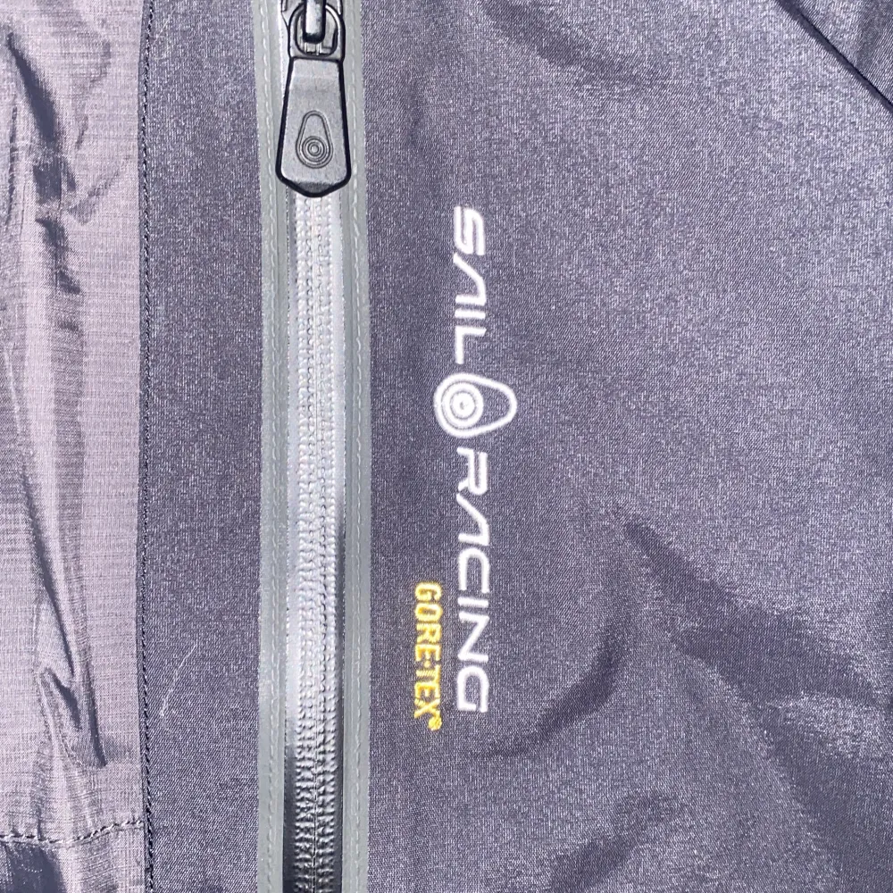 Säljer en svart dunjacka från Sail Racing med GORE-TEX-material. Jackan har en justerbar huva och flera praktiska dragkedjefickor. Perfekt för kalla äventyr med sin robusta design och varma fyllning. Den har en snygg patch med 'Antarctica Expedition' på ärmen. Nypris ca 9000kr. Takit.