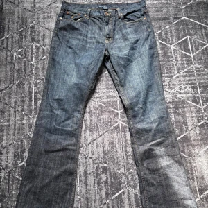 Blå jeans från Ralph Lauren Sport - Dessa Polo Ralph Lauren jeans har en bootcut passform med lite större midja (storleken är W32 men sitter som en W33 eller W34).                 Snygga blå jeans från Ralph Lauren Sport med klassisk femficksdesign och broderad logga. Tillverkade i bomull med en touch av elastan för extra komfort. Perfekta för en avslappnad stil.