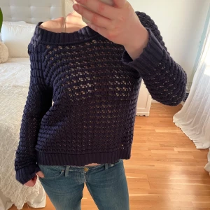 Mörkblå stickad tröja - Säljer en mörkblå stickad tröja med ett luftigt mönster. Tröjan har en avslappnad passform och är bl.a. perfekt för lager-på-lager-stil😍Storlek L men har passform som M.