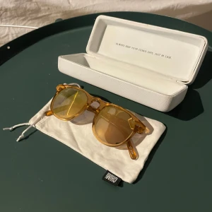 Solglasögon från Chimi - Snygga solglasögon från Chimi i en cool persikofärg. De har en rund form och kommer med ett stilrent vitt fodral. Perfekta för att ge din outfit en färgklick! Använd ett fåtal gånger, skriv vid intresse!