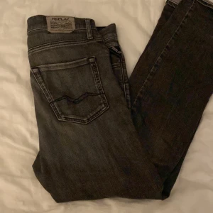 Svarta jeans från Replay - Snygga svarta jeans från Replay med klassisk femficksdesign och en bekväm passform. Perfekta för en stilren look. Märkeslappen syns tydligt på baksidan.