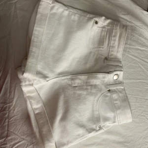 Vita shorts från FB Sister - Snygga vita shorts från FB Sister i en klassisk design. De har en knapp och dragkedja framtill samt praktiska fickor både fram och bak. Perfekta för varma dagar och enkla att matcha med olika toppar. Säljs pga de inte passar längre, använts 1-2 gånger.