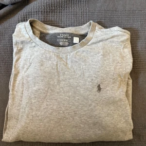 Grå långärmad tröja från Polo Ralph Lauren - Säljer en stilren grå långärmad tröja från Polo Ralph Lauren. Tröjan har en klassisk design med en liten broderad logotyp på bröstet. Perfekt för en avslappnad och snygg look. Sparsamt andvänd. Tvättad fåtal gånger. Skulle säga att den passar alla som är runt 184 och uppåt. Om du har funderingar eller vil ha tydligare bilder så tveka itne med att höra av dig 🤩Pris kan diskuteras vid snabb affär 🫡