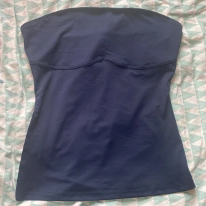 Mörkblå tubtopp från Shein - Säljer en stilren mörkblå tubtopp från Shein. Toppen har en enkel design utan axelband och är perfekt för en minimalistisk look. Tillverkad i ett mjukt och bekvämt material.