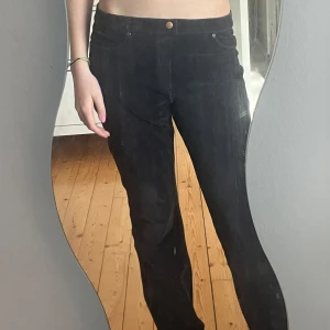 Svarta byxor  - Snygga svarta byxor som är mjuka och har bootcut-stil och är randiga. Byxorna har klassiska fem fickor och en knapp framtil, det står ingen storlek men skulle gissa mellan S-M