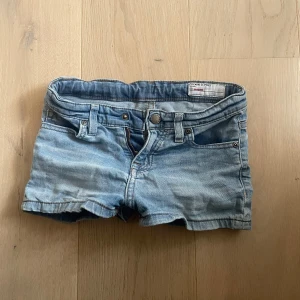 Ljusblå jeansshorts från H&M - Snygga ljusblå jeansshorts från H&M med klassisk femficksdesign och knappgylf. Perfekta för varma sommardagar. De har en lågmidjad passform som ger en avslappnad stil.