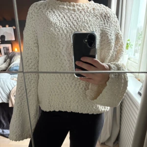 Vit stickad tröja från H&M Divided - Mysig vit stickad tröja från H&M Divided med ett unikt texturerat mönster. Tröjan har långa ärmar och en bekväm passform, perfekt för kyligare dagar. Ett måste i garderoben för en stilren look. Tröjan är lite genomskinlig. Den är också lite större än xxs 