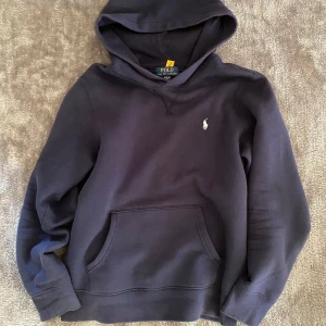 Mörkblå hoodie från Polo Ralph Lauren - Säljer en snygg mörkblå hoodie från Polo Ralph Lauren med klassisk vit logga på bröstet! Storlek L i barn så passar dig runt 165-170! Kom privat vid funderingar😊