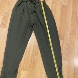 Gröna byxor från Lager 157 - Snygga gröna byxor från Lager 157 i storlek L. Byxorna är tillverkade av 100% polyester och har en bekväm passform med elastisk midja. Perfekta för en avslappnad stil.