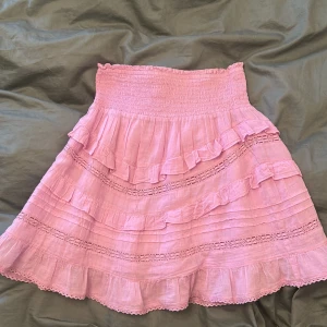 Rosa volangkjol från Neo Noir!!! - Säljer en söt rosa kjol från Neo Noir med flera volanglager och elastisk midja. Pris går att diskuteras! Knappt använd och därför superbra skick!!! 