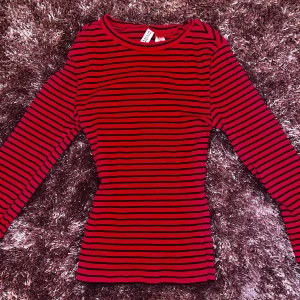 Röd och svart randig tröja - Röd och svart randig ribbad topp, tight passform, mjukt och bekvämt material. Från h&m, använd 1 gång jätte fint skick strl XS.