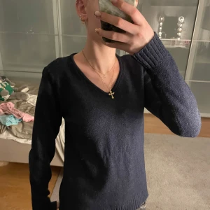 Mörkblå tröja med v-ringning - Säljer en stilren mörkblå tröja med v-ringning. Den är rätt så använd, den har alltså inte kvar samma mjuka material som när den var ny.