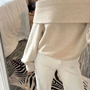 Beige offshoulder tröja - Säljer en stilren beige offshoulder tröja med ribbad design. Tröjan har långa ärmar och en bred krage som ger en elegant look. Perfekt för kyligare dagar. Första bilden är inte min!🤍🫧