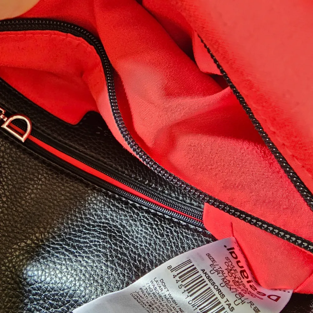Upper flap with magnetic closure An outer pocket and a small pocket inside, both with zipper Inner compartment divided into three spaces, one of them with zipper Mickey Mouse prints with worn effect Patch of a Mickey Mouse comic panel Big pullers in leather effect fabric The flap is a big pocket with its own zip fastener Includes two interchangeable straps: one in leather effect fabric and the other one is a chain Measurements: 25.5 (l.), 12.6 (w.), 13.5 (h.) cm.. Laukut & Käsilaukut.