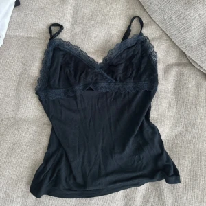 Svart linne med spetsdetaljer - Snyggt svart nattlinne med spetsdetaljer vid halsringningen och smala axelband. 