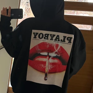 Svart hoodie från Playboy - Säljer en svart hoodie från Playboy. Hoodien har dragkedja framtill och texten 'PLAYBOY' på ärmen. Den är oversized och knappt använd.
