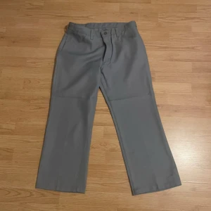 Grå byxor med raka ben - Snygga grå byxor med raka ben och klassisk design. De har en enkel stängning med dragkedja och knapp. Perfekta för en stilren look.