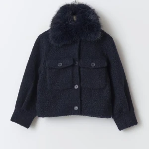 Mörkblå jacka med pälsdetalj - Snygg mörkblå jacka med fluffig pälsdetalj på kragen. Jackan har en klassisk design med knappar framtill och två stora fickor. Storlek 158/164 passa på xxs/xs