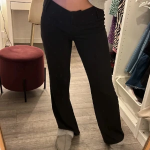 Svarta kostymbyxor  - Snygga svarta bootcut byxor med låg midja. Perfekta för en stilren look. De har en klassisk design som passar till många olika outfits.