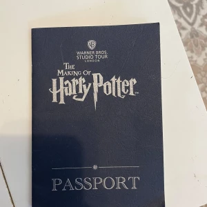 The Making of Harry Potter Passport - Ett pass från Warner Bros. Studio Tour London för 'The Making of Harry Potter'. Innehåller sidor för att samla stämplar och trivia om Gryffindor. Perfekt för fans av Harry Potter som besöker studion.