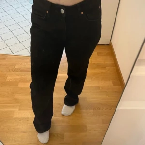 Svarta low waist straight jeans - Säljer ett par svarta low waist straight jeans. De har en klassisk design med knapp och dragkedja framtill. Perfekta för en avslappnad stil.
