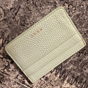 Turkos plånbok från kruk  - Snygg turkos plånbok från kruk i skinn med en stilren design. Den har en rosa insida som ger en fin kontrast. Perfekt för att hålla dina kort och kontanter organiserade.