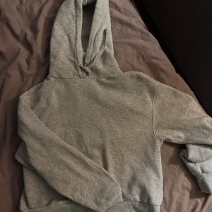 Grå hoodie - Betalas via Swish! Säljer en mysig grå hoodie i bra skick. Perfekt för kyliga dagar eller som ett extra lager. Den har en klassisk design med huva och långa ärmar. Passar både till vardags och avslappnade tillfällen.