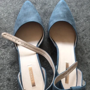 Blå pumps från Esprit 41 - Eleganta blå pumps från Esprit i mocka med spetsig tå och klack. Skorna har en dekorativ fransdetalj vid hälen och en smal rem över foten för extra stil.