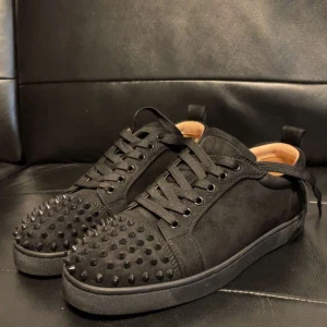 Svarta valentino sneakers med nitar - Snygga svarta sneakers med nitar på ovansidan. Skorna har snörning och är tillverkade i mocka. Perfekta för en edgy stil.