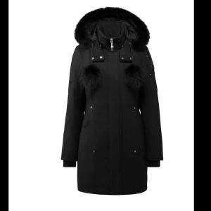 Svart parkajacka med pälsdetaljer - Snygg svart parkajacka med pälsdetaljer på huvan och dragkedja framtill. Jackan har långa ärmar och flera knappar för extra stil. Perfekt för kyliga dagar. Använd 2 vintrar kvittot finns till jackan! Nypris 15.225kr                                                   Pris kan diskuteras vid snabb äffär!