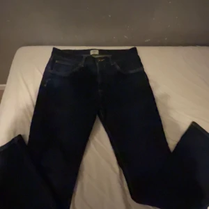 Mörkblå jeans från Bowery - Säljer ett par mörkblå jeans från Bowery i modellen Slim Fit. De är i bra skick och perfekta för både vardag och fest. Klassisk design med fem fickor och knappgylf. Passar till det mesta i garderoben!