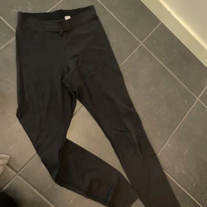 Svarta leggings från Nike - Säljer ett par svarta leggings från Nike i bra skick. De är perfekta för träning eller en avslappnad dag. Materialet är mjukt och stretchigt för bästa komfort. Diskret Nike-logga vid vristen. Passar till det mesta och är ett måste i garderoben!