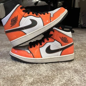 Nike Air Jordans i orange och svart - Snygga Nike Air Jordans i en fräsch kombination av orange, svart och vitt. Skorna har en klassisk hög modell med snörning och en ikonisk Nike-logga på sidan. Perfekta för att ge din stil ett lyft! Väldigt fint skick förutom en liten intryckt del vid tån se bild 3 men det tror jag kan tryckas ut med hjälp av sko block sedan lite crease på tån men så är de på de flesta jordans. Säljer då jag inte kan ha dom längre. Inget og följer med 
