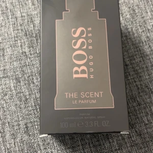 Hugo Boss The Scent Le Parfum - Säljer en elegant och förförisk parfym från Hugo Boss, The Scent Le Parfum. Flaskan rymmer 100 ml och har en stilren design i svart med rosa detaljer. Perfekt för den som vill ha en sofistikerad doftupplevelse. 