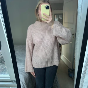 Beige stickad tröja - Mysig beige stickad mohair tröja med lång ärm och hög krage. Perfekt för kyliga dagar och ger en avslappnad look. Passar bra till jeans eller leggings.
