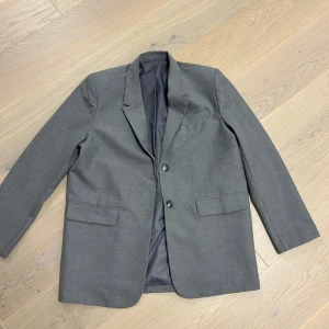 Grå kavaj från NA-KD - Snygg grå kavaj från NA-KD i mycket bra skick. Perfekt för både vardag och fest. 