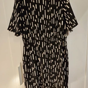 Svart och vit mönstrad klänning från Cappuccini - Snygg svart klänning med vitt geometriskt mönster från Cappuccini. Använd en gång.