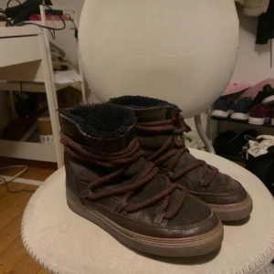 Bruna boots från Inuikii - Säljer ett par bruna boots från Inuikii med snörning och mjukt foder. Perfekta för kalla dagar med sin varma insida och robusta design.